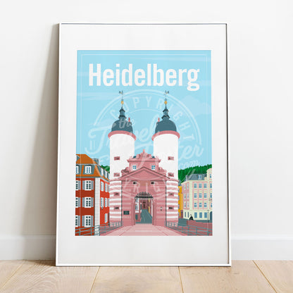 a frame with a poster of the Heidelberg Bridge Gate, placed on a parquet floor resting against a white wall