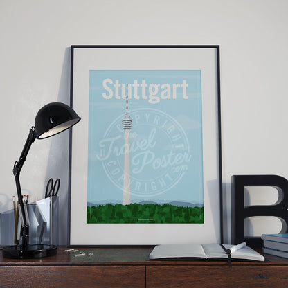 a frame with a poster of the Stuttgart TV Tower, placed a wooden sideboard with a table lamp and stationery supplies