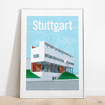 a frame with a poster of the Stuttgart Weissenhof Museum, placed on a parquet floor resting against a white wall