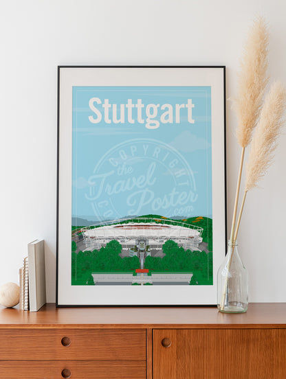 a frame with a poster of the Stuttgart Neckarstadion, placed on a wooden sideboard with some books and reeds in a glass bottle